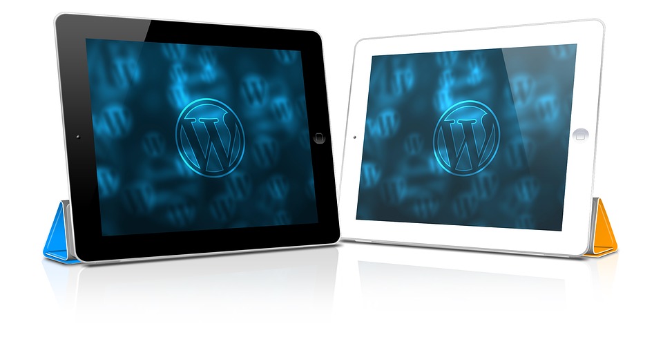 Two iPads, one black and one white, displaying the WordPress logo.